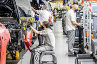 Staff building cars on production line