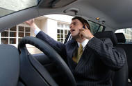 Man wearing suit on phone in car