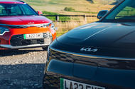 black kia niro in front of red kia niro