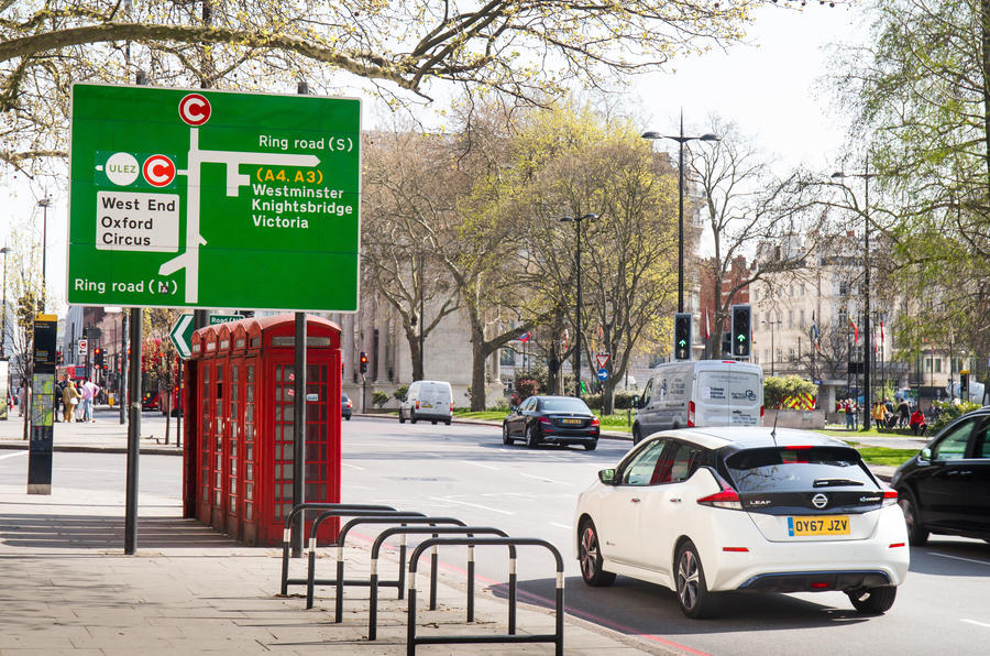 A Mk2 Nissan Leaf driving past a ULEZ road sign in Central London