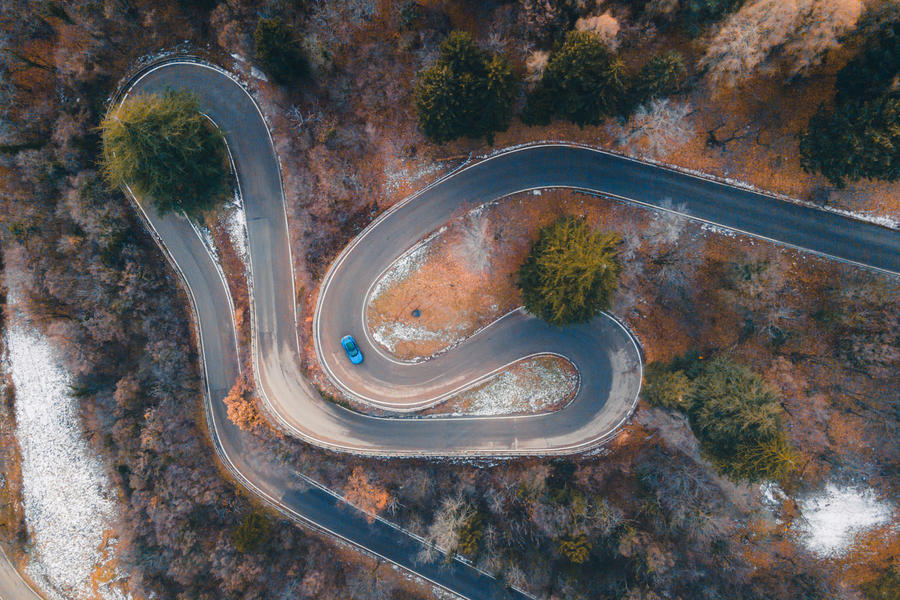 Ferrari Purosangue driving through Italian hills – viewed from above