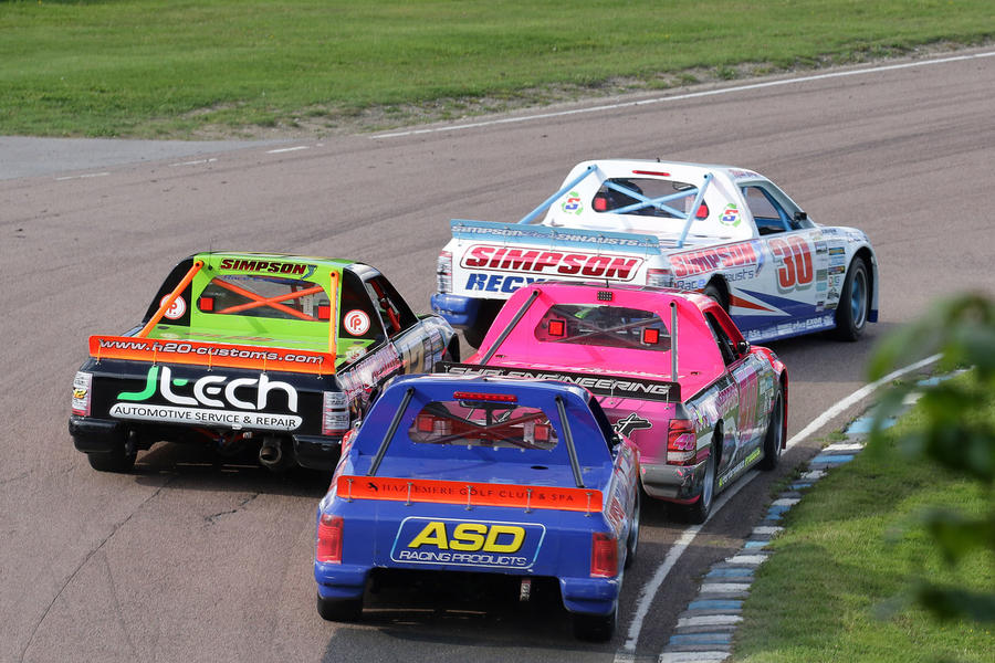 Pick-up racing – pack of trucks diving into bend