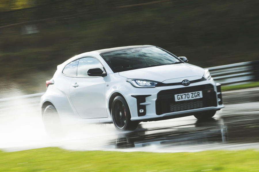 White Toyota GR Yaris driving on very wet track