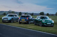 All-electric MINI range, inluding the Cooper, Aceman and Countryman, pictured in front of a scenic countryside backfrop 